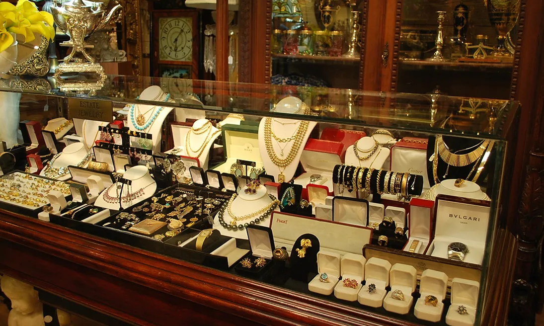 Expert evaluating antique jewelry and collectibles at Gold Mind Jewelers Sharon